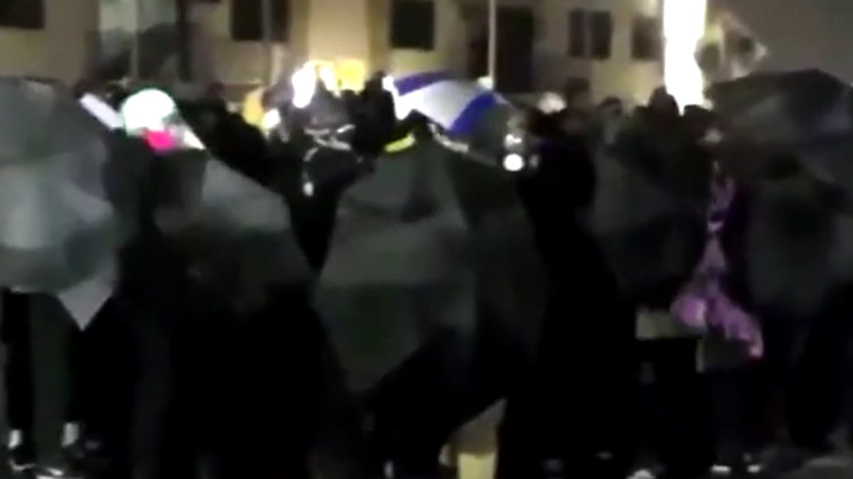 Umbrella barricade versus police barricade in Minneapolis