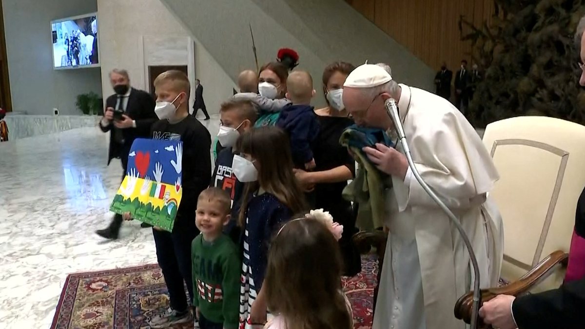 Pope Francis kisses the Ukrainian flag