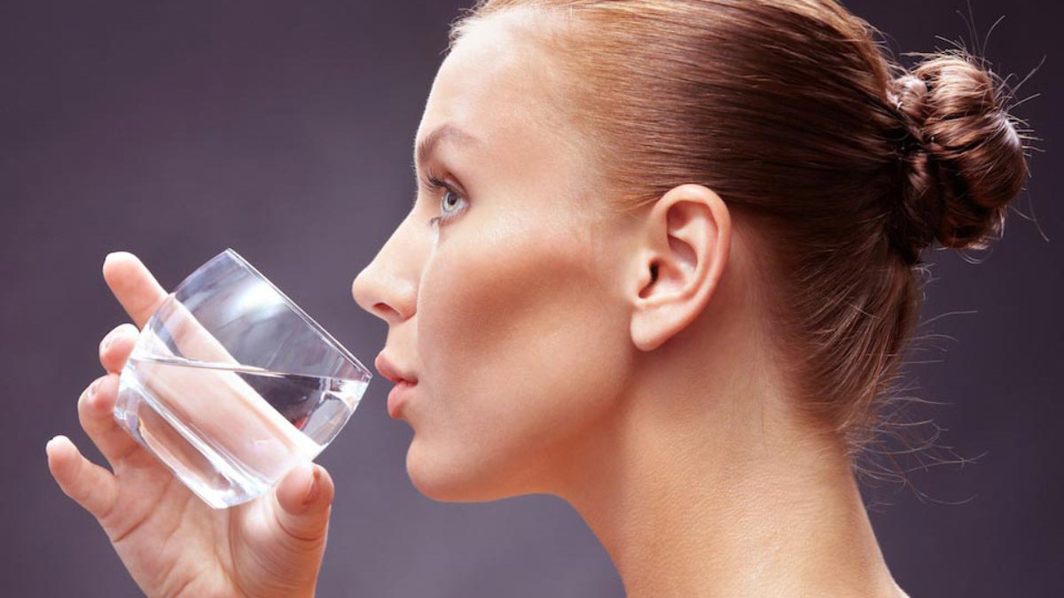 Вода без залога. Девушка со стаканом воды. Девушка пьет воду из стакана. Девушка пьет воду на фотосессии. Женщина запивает водой.