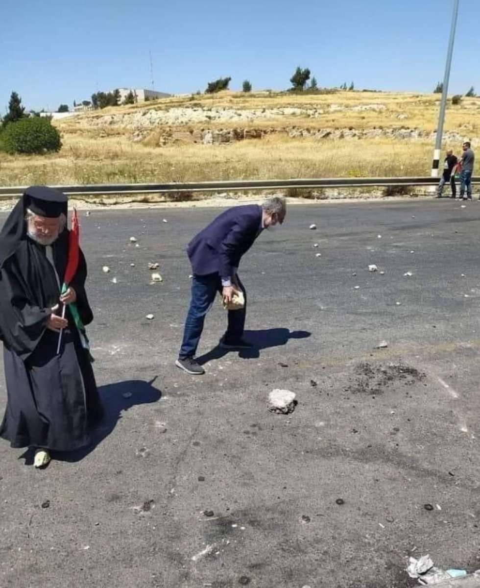 Catholic Archbishop Yulio stands before Israeli soldiers with the Palestinian flag #2