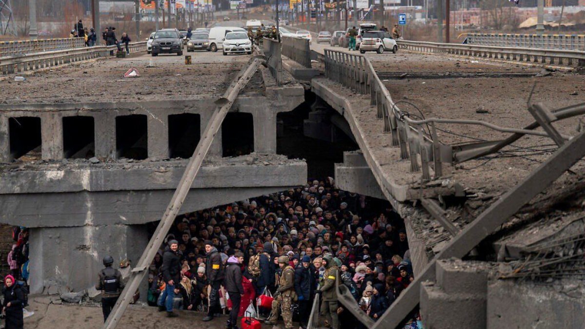 Evacuations take place over the ruined bridge in the city of Irpin, next to Kiev