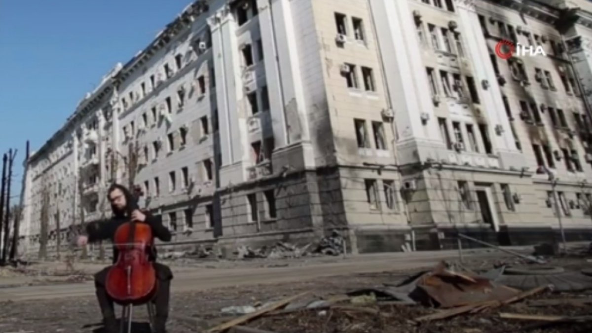 Ukrainian cellist plays cello in front of buildings destroyed by Russian attacks