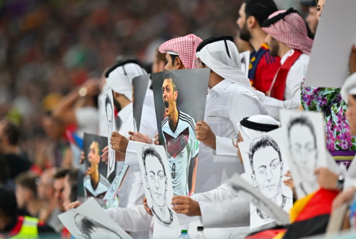 المشجعون القطريون يرفعون ملصقات مسعود أوزيل خلال مباراة إسبانيا وألمانيا رقم 1