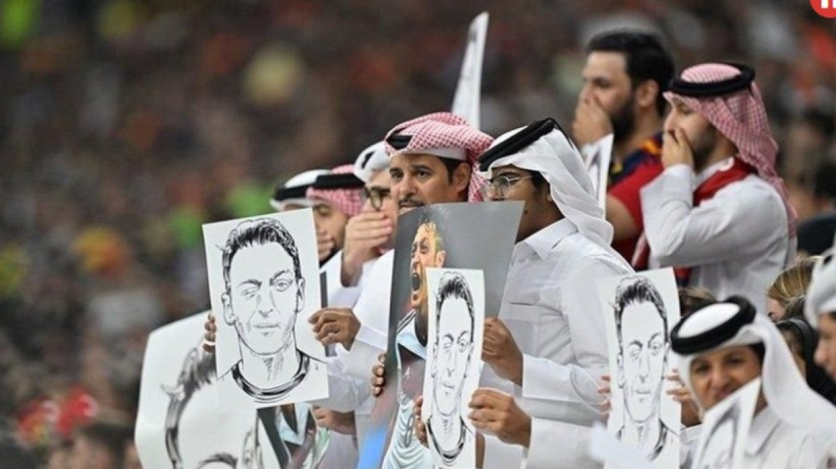 المشجعون القطريون يرفعون ملصقات مسعود أوزيل خلال مباراة إسبانيا وألمانيا رقم 2