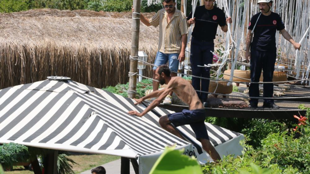 Antalya'da demirlere tırmandı, polislerden kaçıp şemsiyenin üzerine çıktı