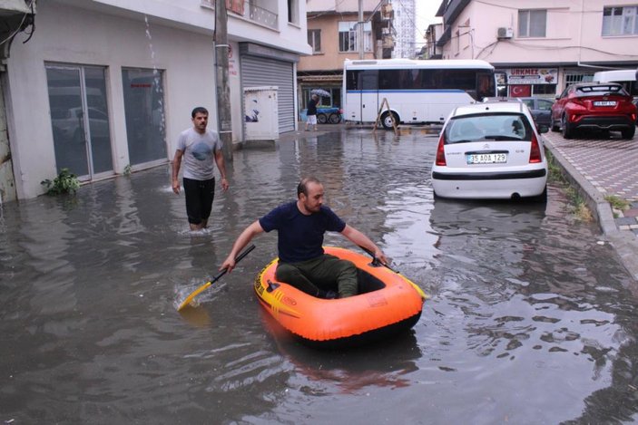 İzmir'de yağış sonrası göle dönen sokaktan botla geçti